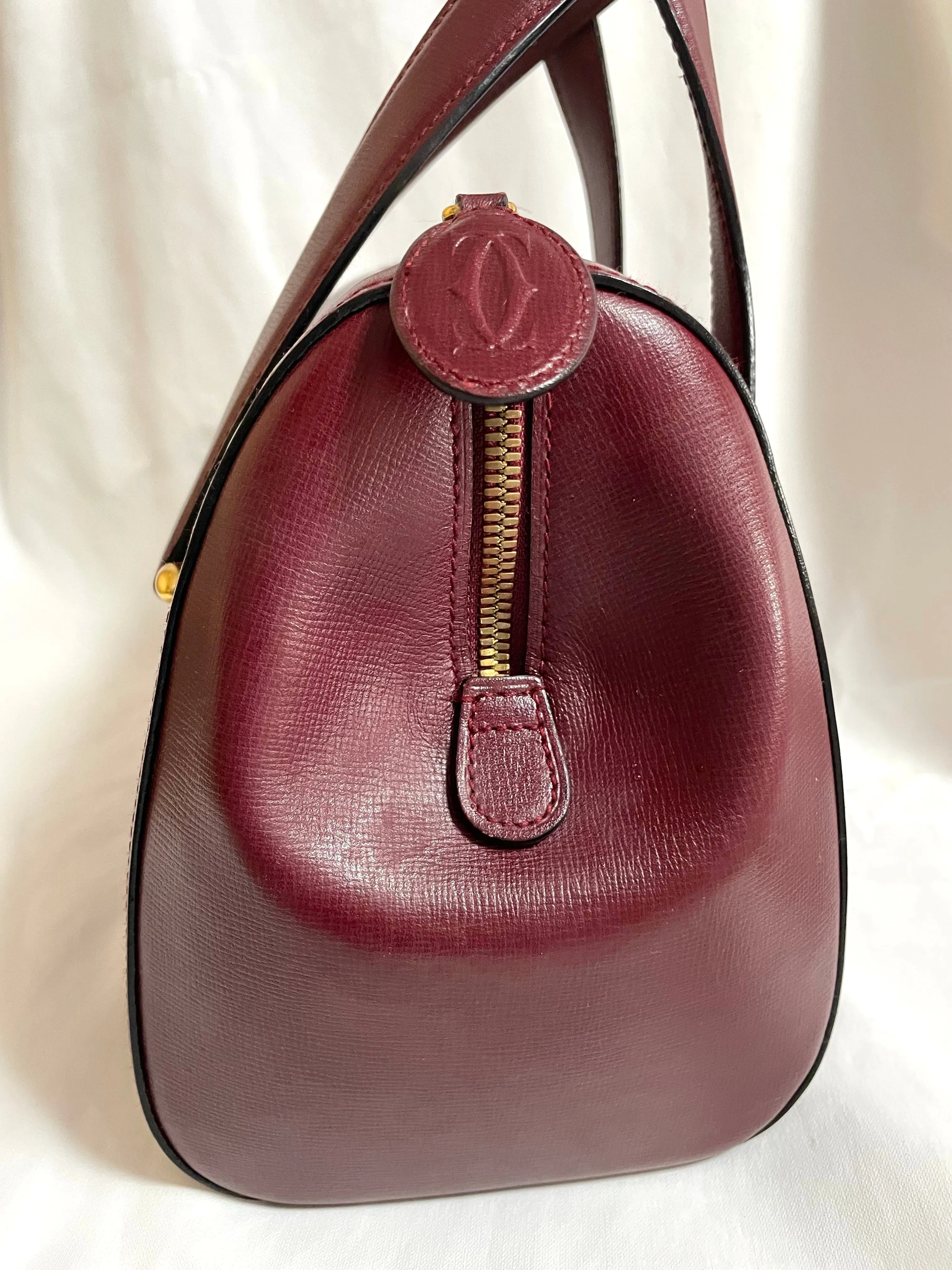 Vintage Cartier classic wine, bordeaux leather handbag purse with bullet design gold hardware at handles. Must de Cartier. 0408171
