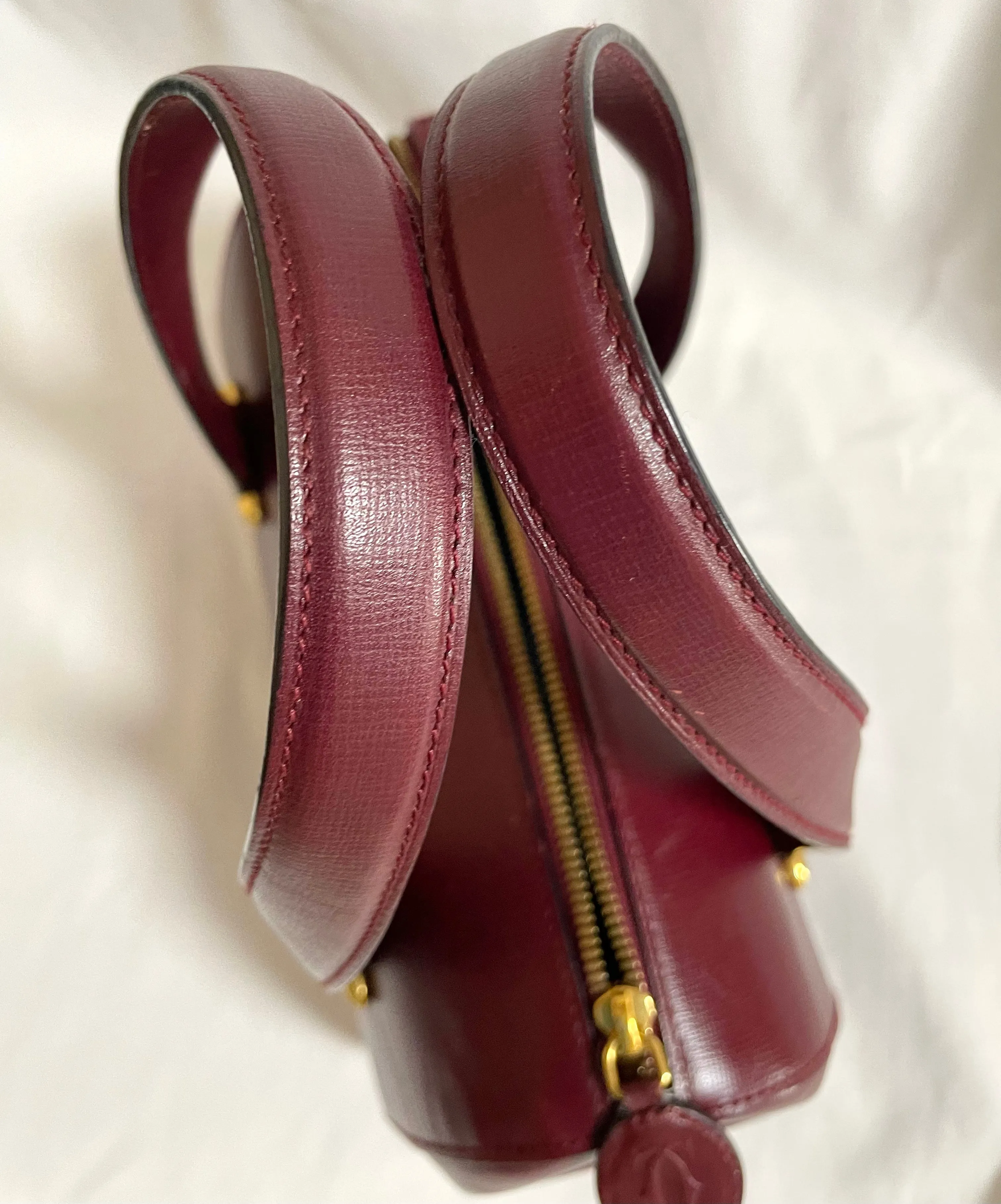 Vintage Cartier classic wine, bordeaux leather handbag purse with bullet design gold hardware at handles. Must de Cartier. 0408171