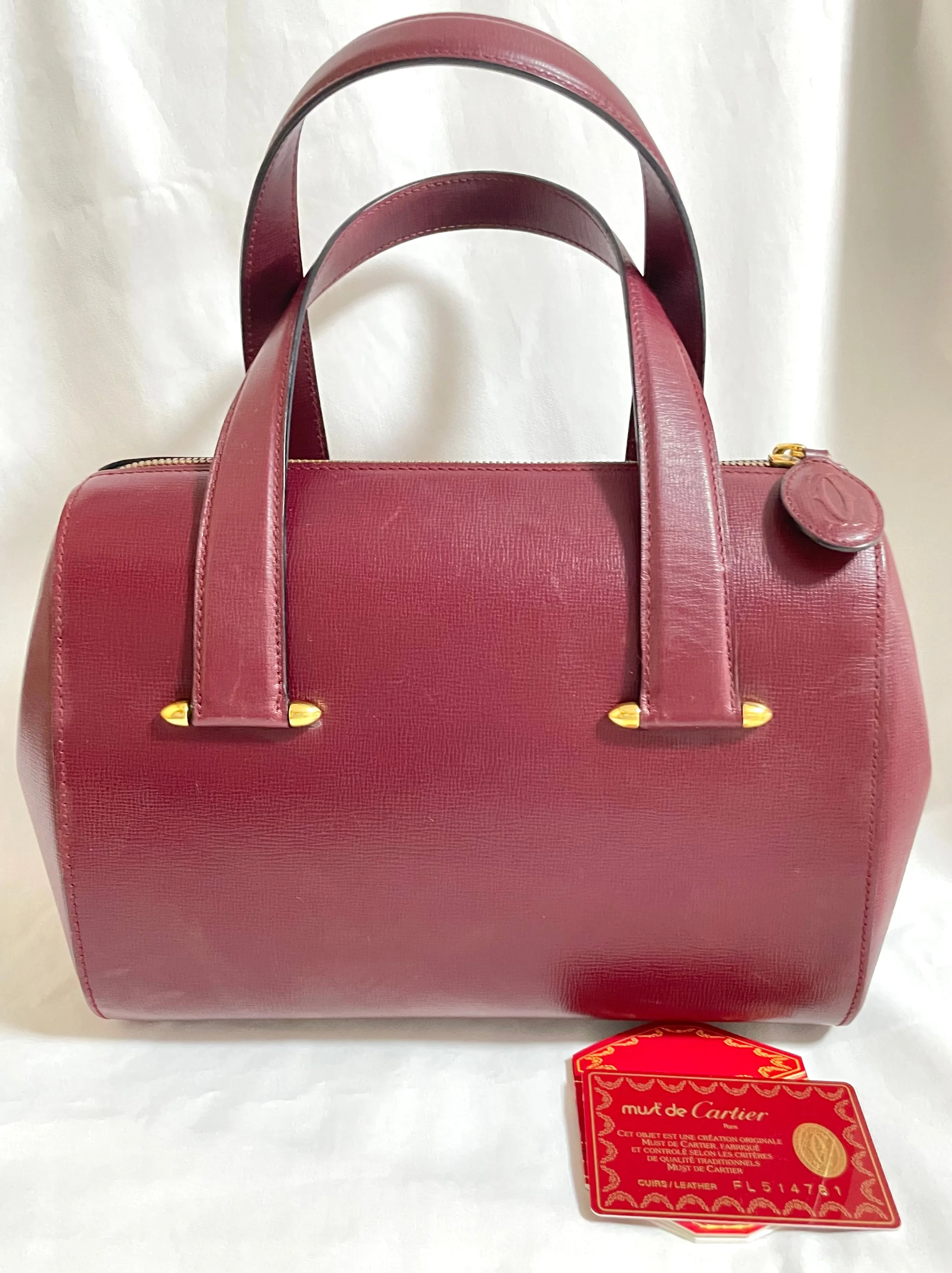 Vintage Cartier classic wine, bordeaux leather handbag purse with bullet design gold hardware at handles. Must de Cartier. 0408171