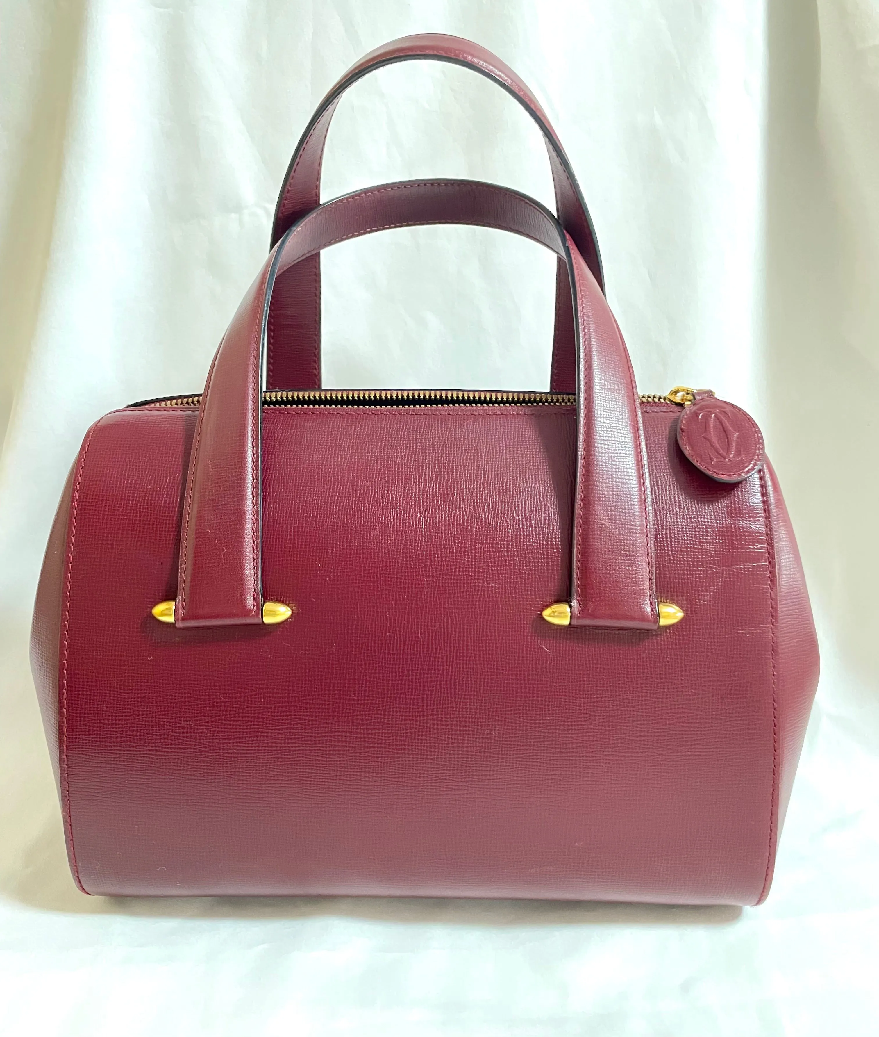 Vintage Cartier classic wine, bordeaux leather handbag purse with bullet design gold hardware at handles. Must de Cartier. 0408171