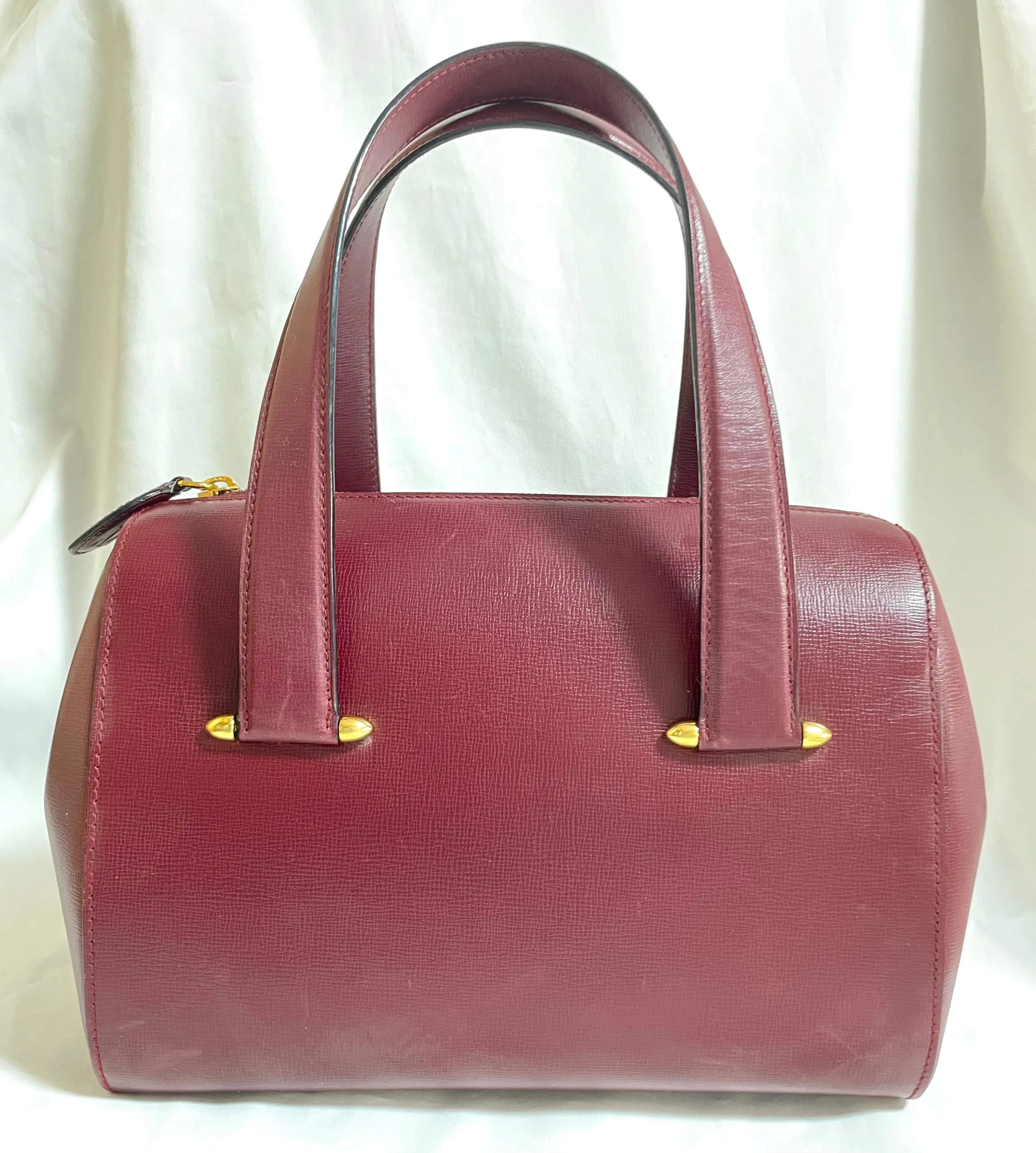 Vintage Cartier classic wine, bordeaux leather handbag purse with bullet design gold hardware at handles. Must de Cartier. 0408171