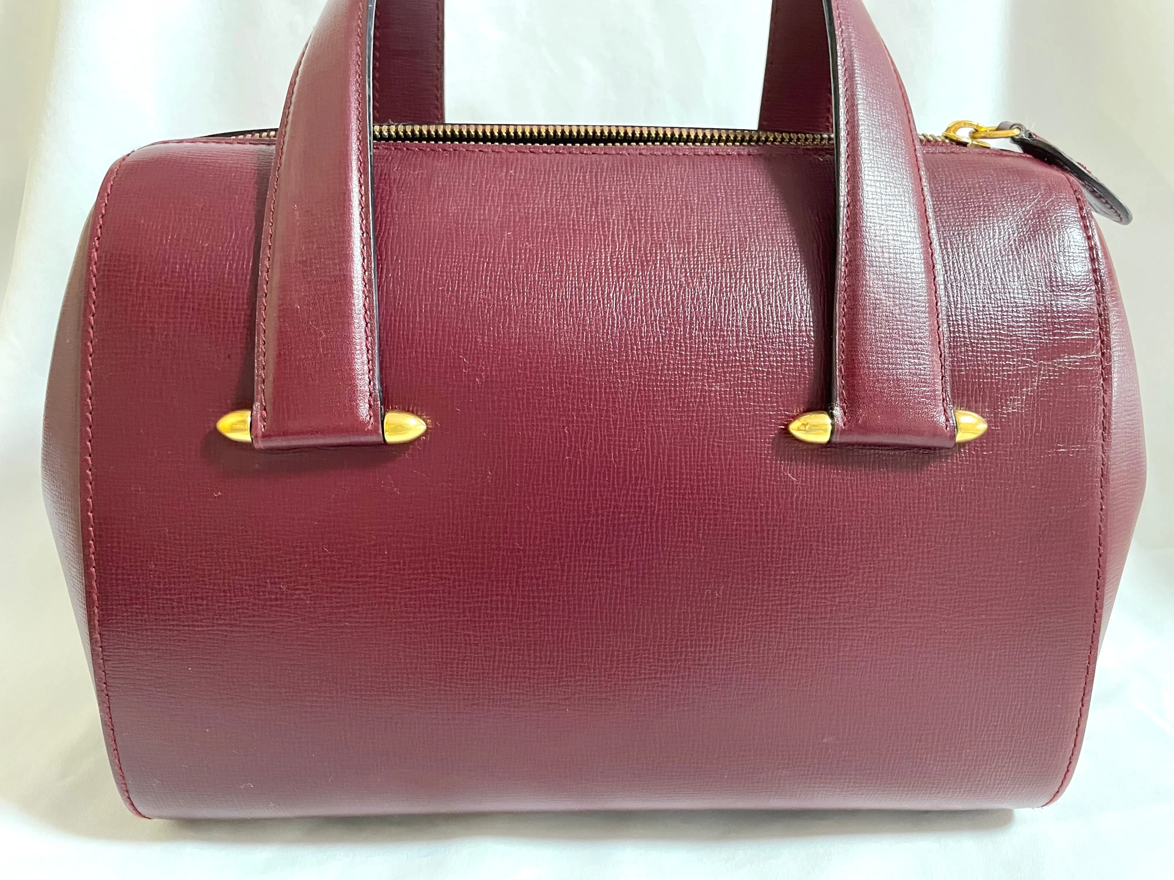 Vintage Cartier classic wine, bordeaux leather handbag purse with bullet design gold hardware at handles. Must de Cartier. 0408171