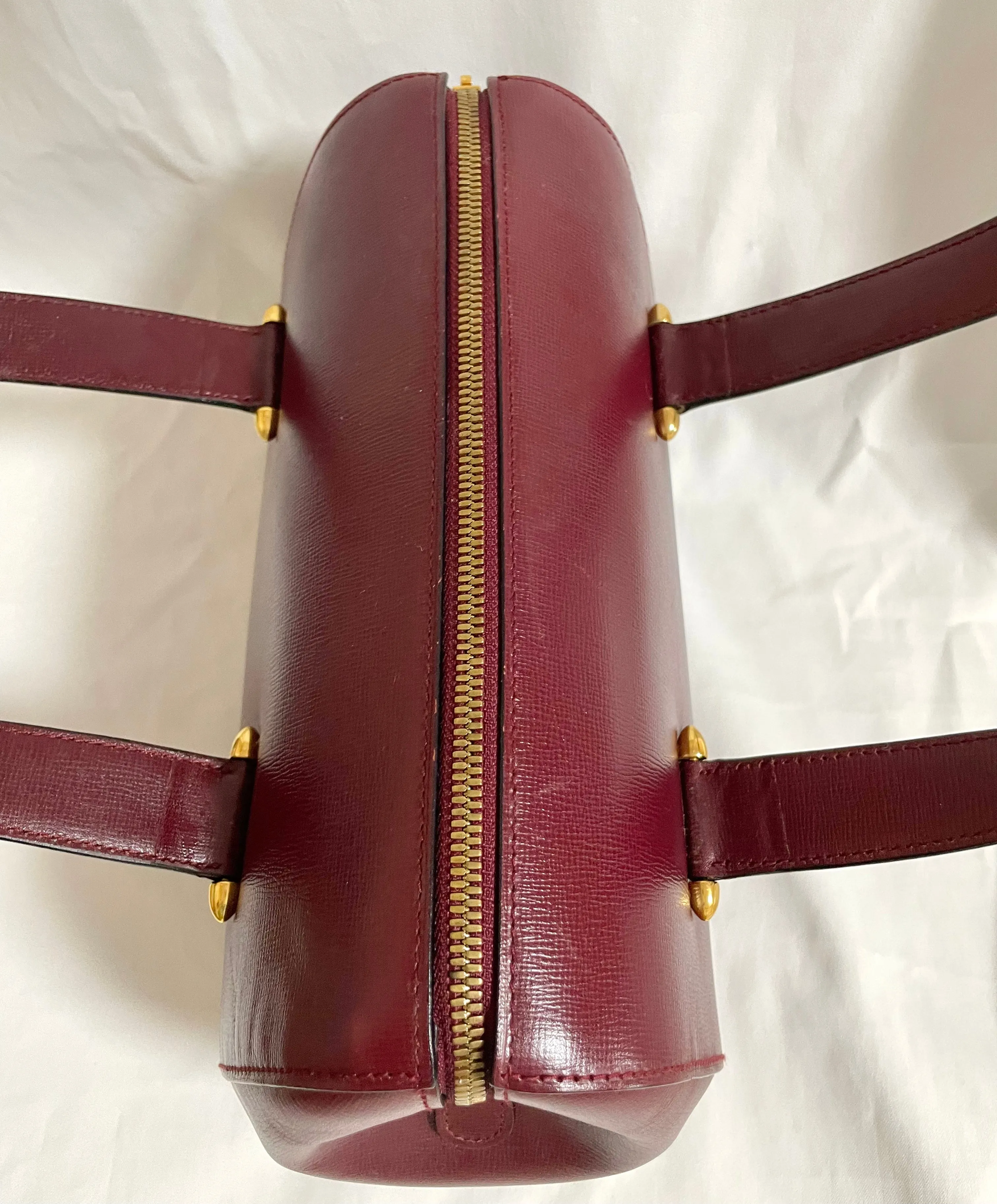 Vintage Cartier classic wine, bordeaux leather handbag purse with bullet design gold hardware at handles. Must de Cartier. 0408171